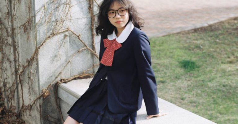 Student Visa - A girl in a school uniform sitting on a bench
